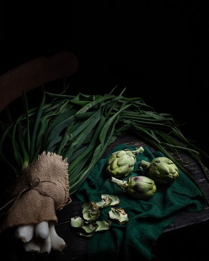 A vertical dark shot of spring onions and brussels sprouts