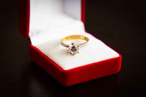 A closeup shot of a wedding ring in a red box isolated on a dark background
