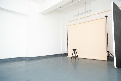 An empty minimalistic photography studio with a chair under the lights - fashion concept