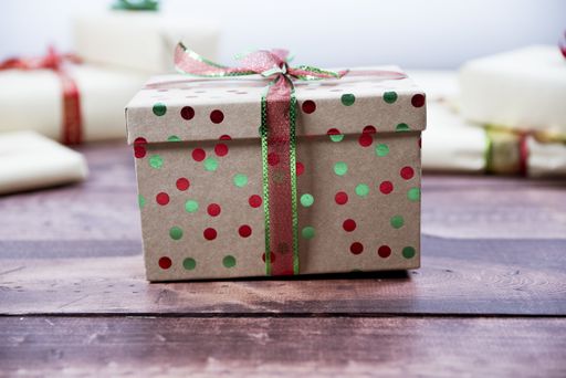 A selective closeup shot of a decorated gift box on a wooden surface