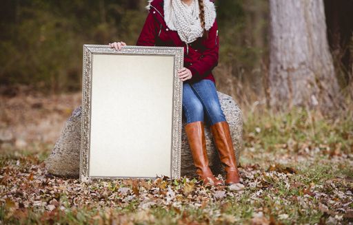 A selective shot of a person holding a blank picture frame as a space for your text