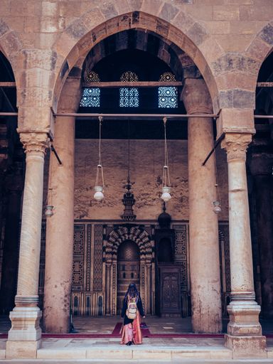A vertical shot of a person visiting the ancient building in Cairo, Egypt