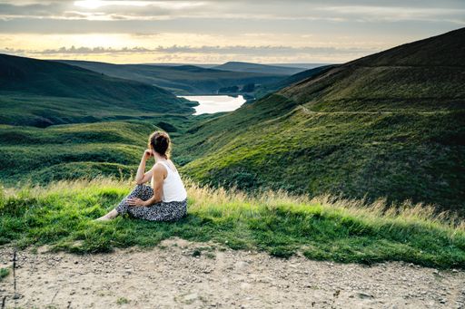 Wessenden Head Reservoir seen from the drone, woman watching sunset at Peak District National Park during summer time, England, UK