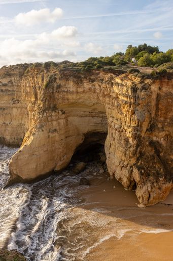 A vertical shot of the beautiful cliffs on the shore. Rocha do Leao, Portimao, Portugal.
