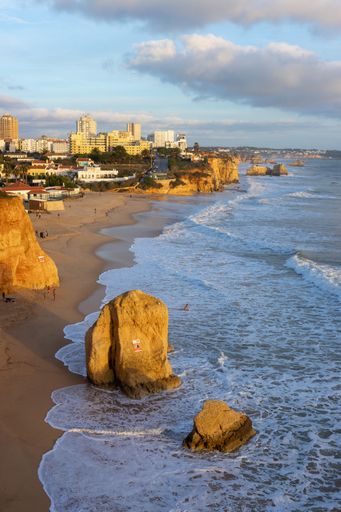 A vertical shot of the shoreline with the cliffs and the city. Vau beach, Portimao, Portugal.