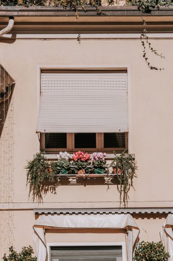A facade of building with windows and plants in Stresa, Italy