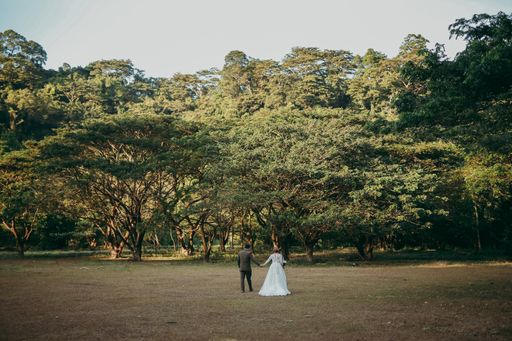 A bride and a groom walking in the forest on a sunny day