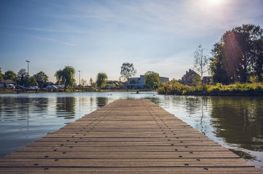 A beautiful landscape shot of a dock on a sunny afternoon  surrounded by houses and trees