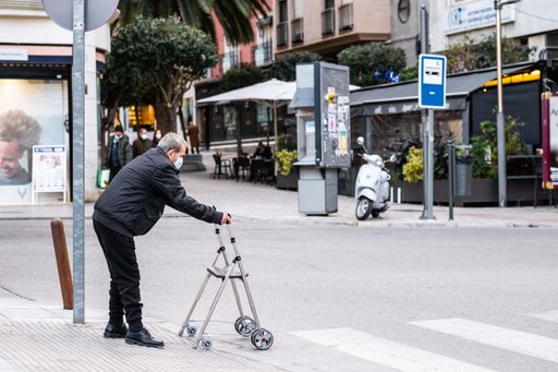 A Elderly man crossing the street with a walker in the city of Jaen
