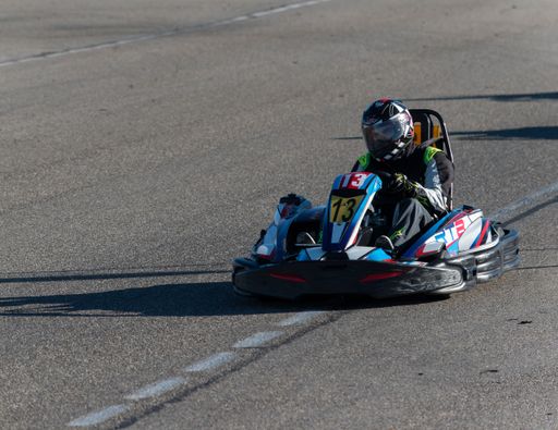 A closeup of a Man racing Go-cart on karting circuit