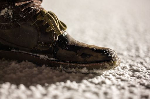 A close-up shot of man's boot on the snow