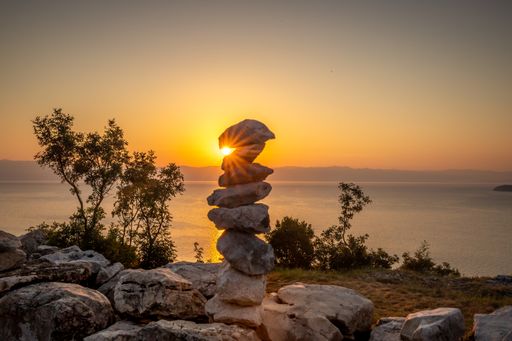 The Coast of Brsec in Istria illuminating the Adriatic Sea in the sunrise with a scene of rock stacks on the edge of a body of water, Croatia