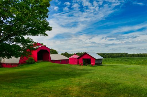 A beautiful view of red barn on the farm in Pennsylvania with a blue sky