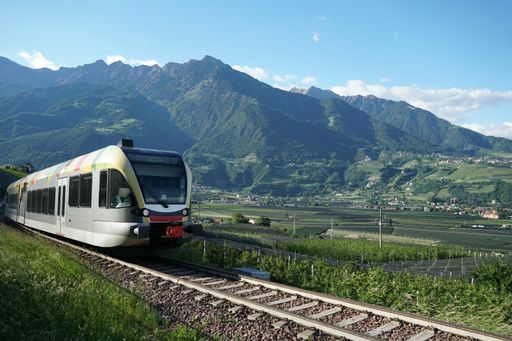 The typical and original colourful train running up and down the Venosta/Winschgau valley, South Tirol, Italy.