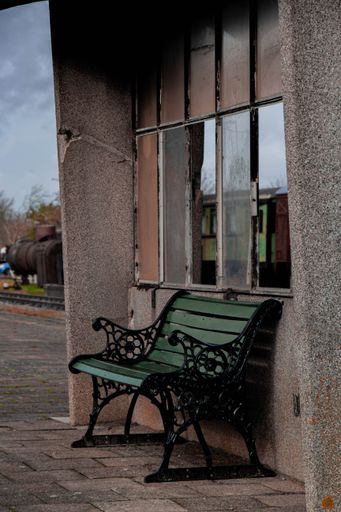 A vertical shot of an old bench in an old waiting area of an abandoned train station