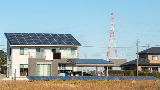 An eco-friendly house with solar panels near an electric pole on a sunny morning