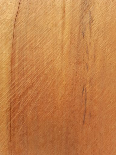 A vertical shot of a wooden surface with scratches on it