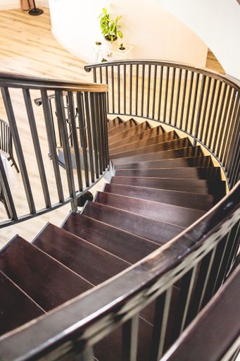 A vertical shot of a curvy brown staircase in a modern house