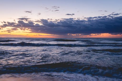 A fantastic shot of stormy wavy seawater with a dramatic sunset sky above