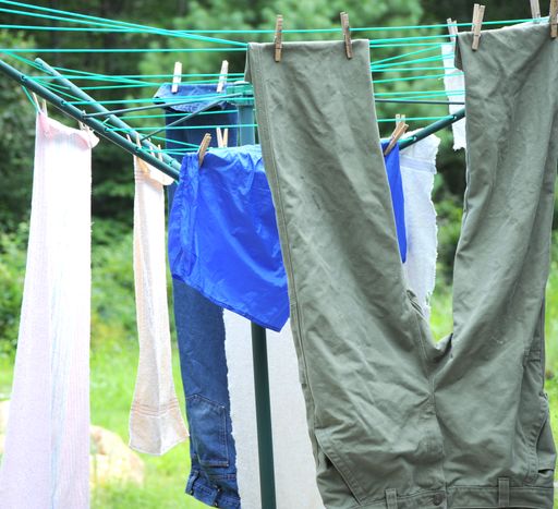 A vertical of laundry hanging and drying on ropes against the blurry green background