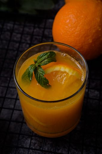 A vertical shot of orange juice decorated with mint