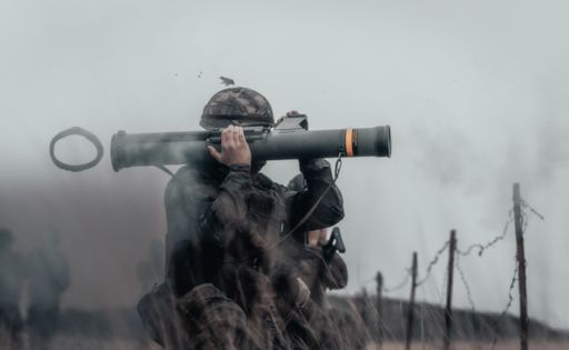 A closeup shot of a soldier in a field firing bazooka