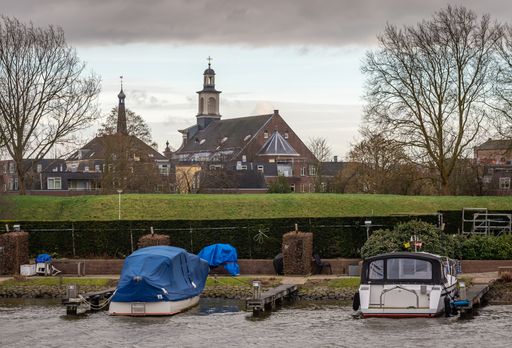 A distant view of the tower of St. Nicolas Pieck church by the water in Gorinchem, Netherlands