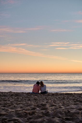 A vertical shot of two girls enjoying a beautiful sunset in Laguna Beach, California