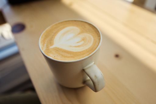 A closeup shot of a latte with a heart in a coffee shop