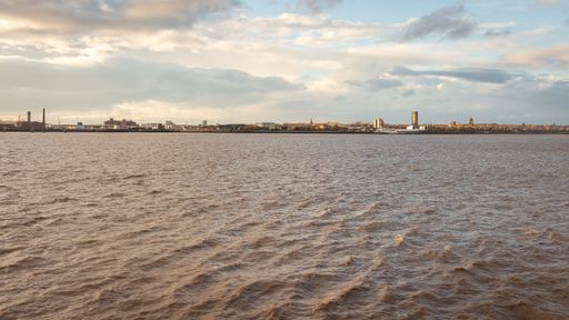 A beautiful shot of a lake with the city of Liverpool in the United Kingdom across from it