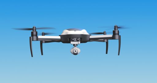 A low angle shot of a drone flying on blue sky in bright sunlight