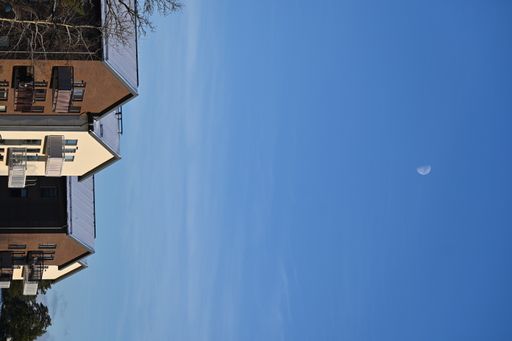 A row of brown and white apartment buildings under a blue sky