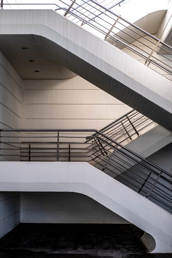 A vertical shot of a white staircase inside a building