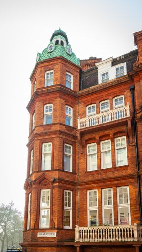 A vertical shot of a beautiful building  made of brinks with white tall windows