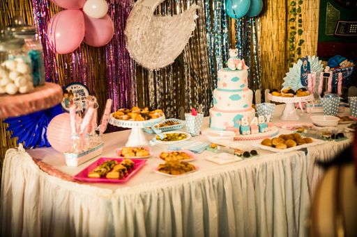A beautiful shot of gender reveal  party table with cake and blue and pink plate, fork and napkins