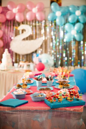 A beautiful shot of gender reveal  party table with cake and blue and pink plate, fork and napkins