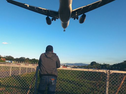 A man look at an airplane landing at Taipei Songshan Airport