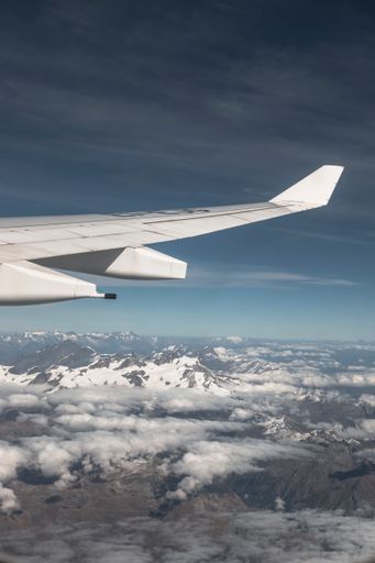 A view of an airplane wing and snowy mountains