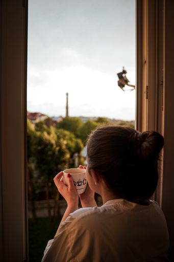 A vertical shot of a Caucasian woman standing near the window