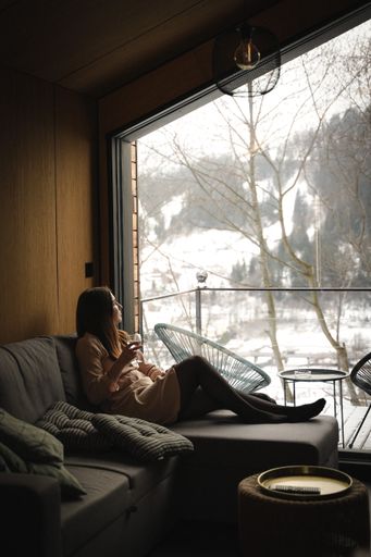 A vertical shot of a Caucasian woman standing near the window