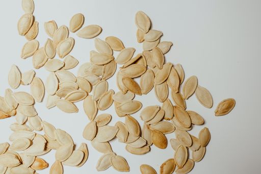 A top view of pumpkin seeds on a white background