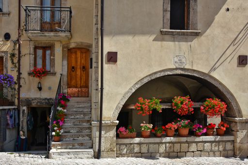 The facade of a house with entrance and windows decorated with flowers in Pescocostanzo