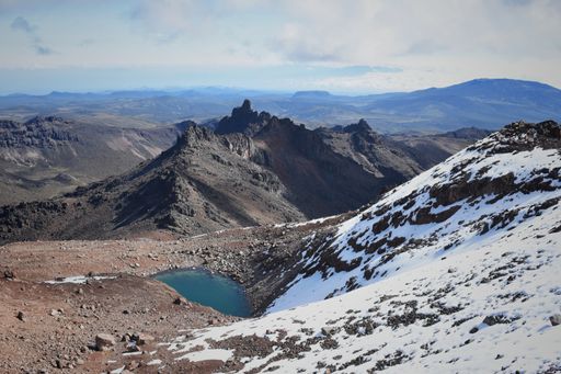 A scenic view of Lake Michaelson resting under the point of the mount Kenya partially covered by snow