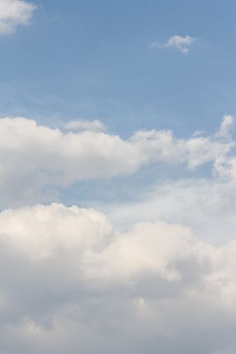 A vertical shot of the clouds of the sky during daytime