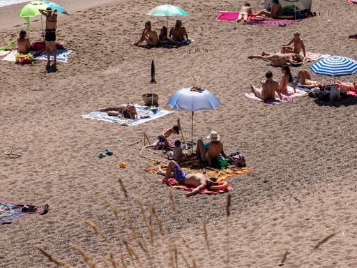 A group of tourists enjoying the beach on a sunny summer day in Costa brava, Spain