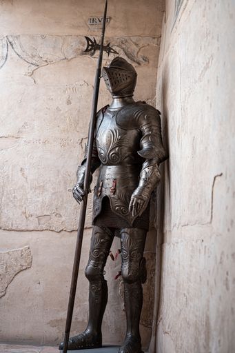 An ancient medieval armor with a spear in a castle