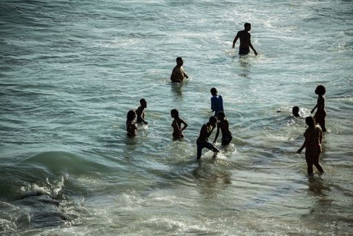 A beautiful shot of people bathing in the water at Paciencia beach in Salvador, Bahia, Brazil