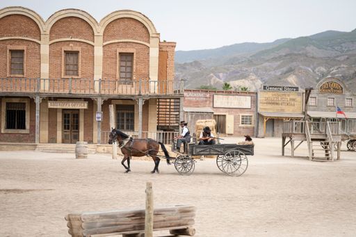 A Wild West movie set with a horse carriage with a prisoner