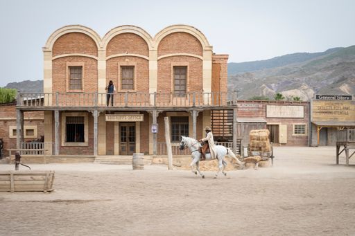 A Wild west movie set with men fighting and a galloping horse