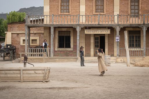 A vWild west movie set with some men fighting in a gunfight
